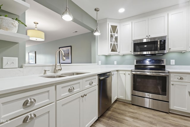 720 Springfork Dr, Cary, NC 27513 - kitchen featuring appliances with stainless steel finishes, hanging light fixtures, white cabinetry, light countertops, and glass insert cabinets