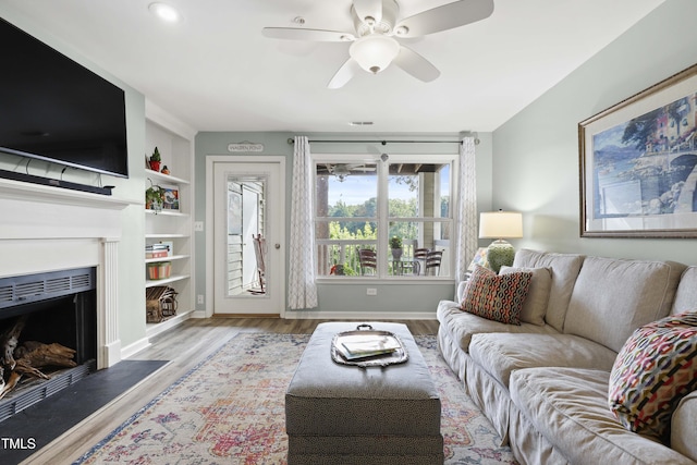720 Springfork Dr, Cary, NC 27513 - living area featuring wood finished floors, ceiling fan, a fireplace, and built in shelves
