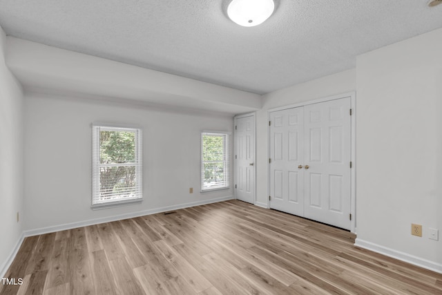 82 Forest Oaks Dr, Durham, NC 27705 - unfurnished bedroom featuring light wood finished floors and a textured ceiling