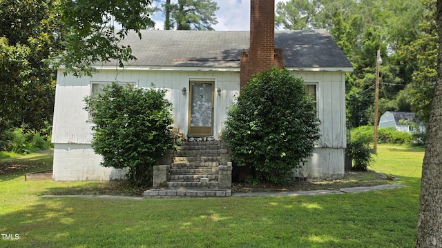 1015 Wait Ave, Wake Forest, NC 27587 - view of front facade with a front yard, a chimney, entry steps, and a shingled roof