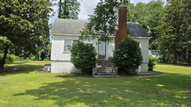 1015 Wait Ave, Wake Forest, NC 27587 - view of front of home featuring a chimney, a front yard, entry steps, and a shingled roof