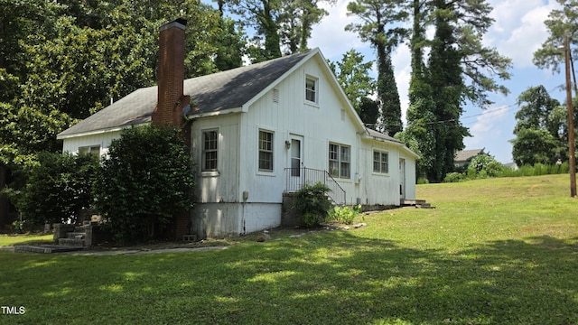 1015 Wait Ave, Wake Forest, NC 27587 - view of side of property featuring a lawn, a chimney, and board and batten siding