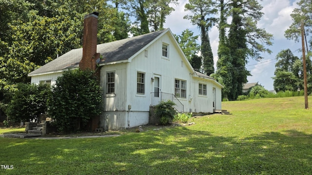 1015 Wait Ave, Wake Forest, NC 27587 - view of side of home featuring a chimney, a yard, and board and batten siding