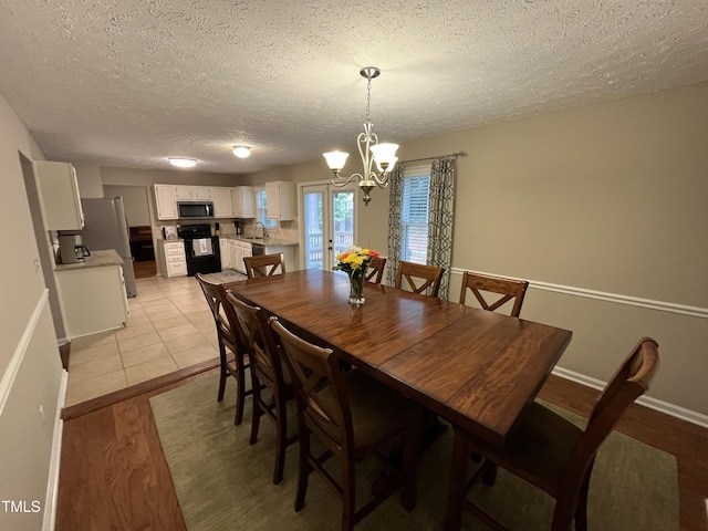106 Carmel Woods Ct, Wake Forest, NC 27587 - dining space featuring a chandelier, a textured ceiling, and light wood finished floors