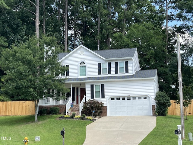 106 Carmel Woods Ct, Wake Forest, NC 27587 - traditional-style house with driveway, covered porch, an attached garage, and a shingled roof