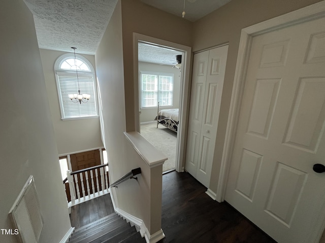 106 Carmel Woods Ct, Wake Forest, NC 27587 - stairway with a textured ceiling, plenty of natural light, wood finished floors, and a chandelier