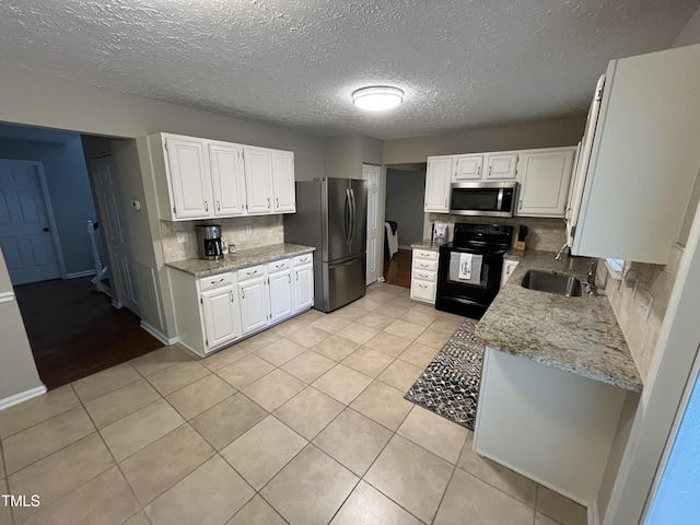 106 Carmel Woods Ct, Wake Forest, NC 27587 - kitchen featuring appliances with stainless steel finishes, decorative backsplash, light stone counters, white cabinets, and a textured ceiling