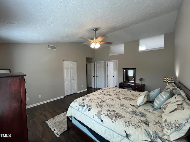 106 Carmel Woods Ct, Wake Forest, NC 27587 - bedroom featuring a textured ceiling, dark wood-style flooring, ceiling fan, multiple closets, and high vaulted ceiling