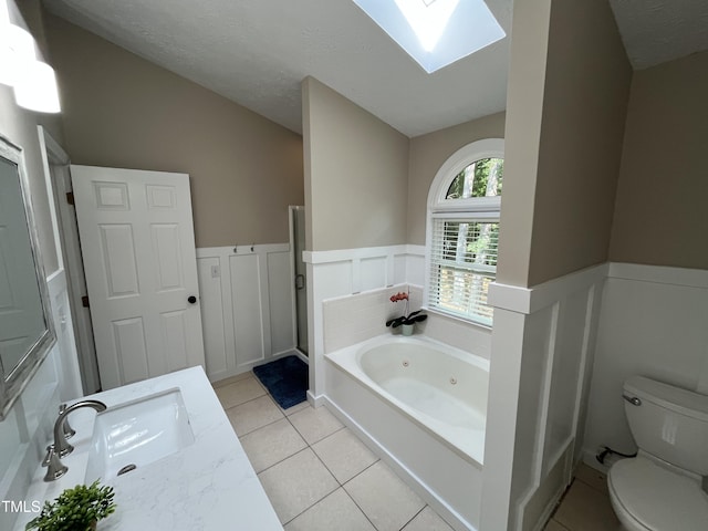 106 Carmel Woods Ct, Wake Forest, NC 27587 - full bath with a skylight, a jetted tub, vanity, tile patterned floors, and wainscoting