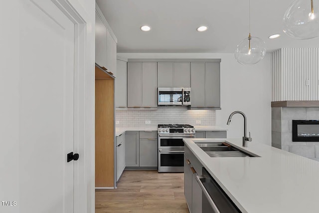 136 E End Ave, Durham, NC 27703 - kitchen featuring stainless steel appliances, gray cabinets, light countertops, light wood-style flooring, and recessed lighting