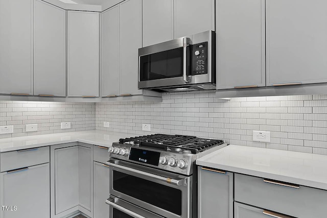 136 E End Ave, Durham, NC 27703 - kitchen with stainless steel appliances, light countertops, gray cabinetry, and decorative backsplash