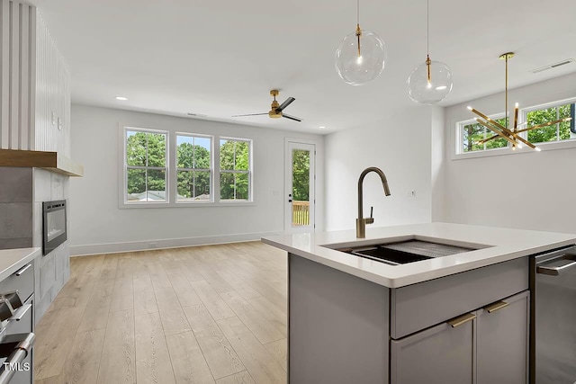 136 E End Ave, Durham, NC 27703 - kitchen featuring gray cabinets, light countertops, light wood finished floors, a center island with sink, and pendant lighting