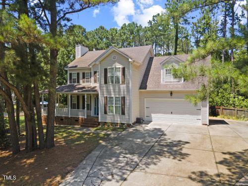 6425 Cross Ridge Dr, Holly Springs, NC 27540 - view of front of house with driveway, a porch, a garage, and a chimney