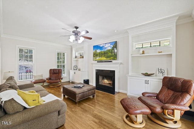 6425 Cross Ridge Dr, Holly Springs, NC 27540 - living room featuring ornamental molding, a fireplace with flush hearth, light wood finished floors, built in shelves, and a ceiling fan