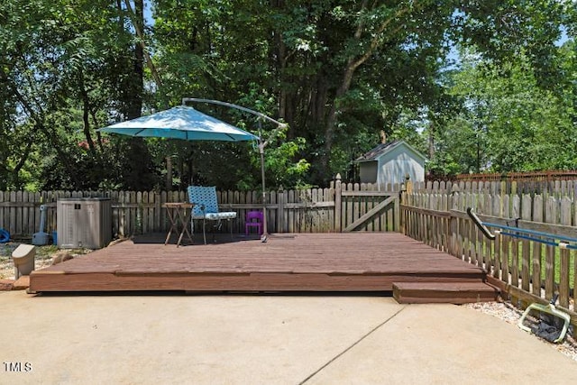 6425 Cross Ridge Dr, Holly Springs, NC 27540 - deck featuring a fenced backyard, a patio, a storage shed, and view of wooded area
