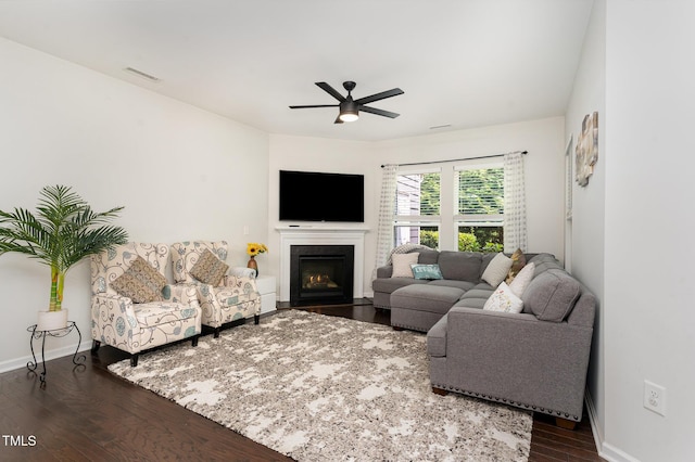 155 Writing Rock Pl, Apex, NC 27539 - living area featuring dark wood finished floors, a ceiling fan, and a warm lit fireplace