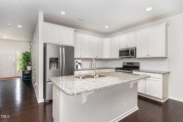 155 Writing Rock Pl, Apex, NC 27539 - kitchen with stainless steel appliances, dark wood finished floors, tasteful backsplash, light stone countertops, and recessed lighting