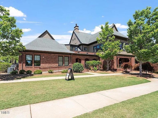 155 Writing Rock Pl, Apex, NC 27539 - tudor-style house with a front lawn, brick siding, and a chimney