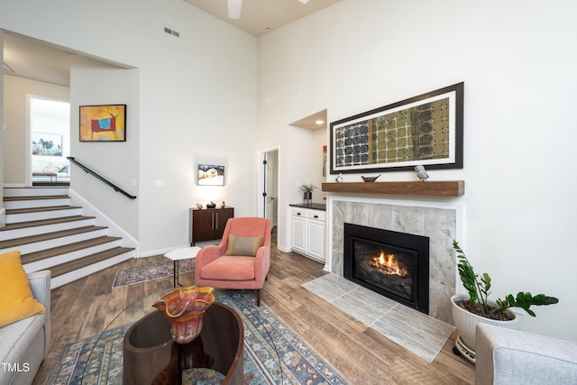 506 Cottage Ln, Durham, NC 27713 - living area with a fireplace, wood finished floors, stairs, a ceiling fan, and a towering ceiling
