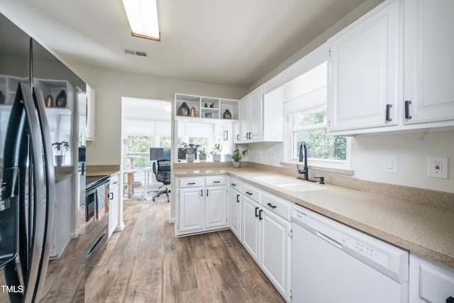 506 Cottage Ln, Durham, NC 27713 - kitchen with refrigerator with ice dispenser, white dishwasher, white cabinetry, light wood-style flooring, and light countertops