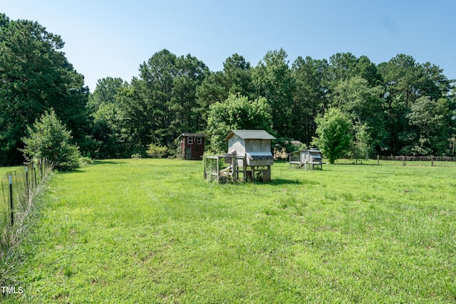 5840 Rocking Chair Dr, Youngsville, NC 27596 - view of yard with exterior structure, an outdoor structure, and a wooded view