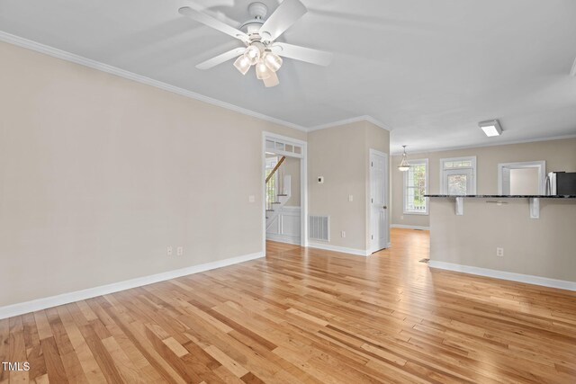 1806 White Dogwood Rd, Apex, NC 27502 - unfurnished living room with light wood-style flooring, crown molding, and a ceiling fan