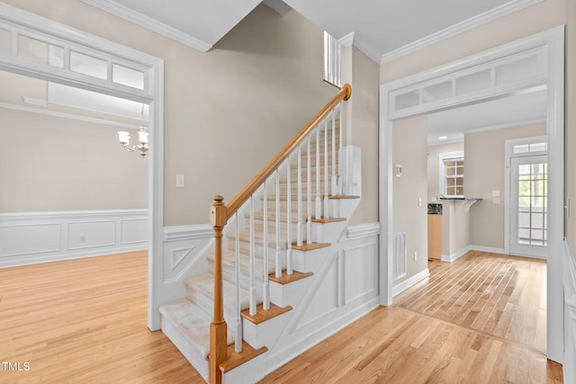 1806 White Dogwood Rd, Apex, NC 27502 - stairway with wood finished floors, ornamental molding, and a chandelier