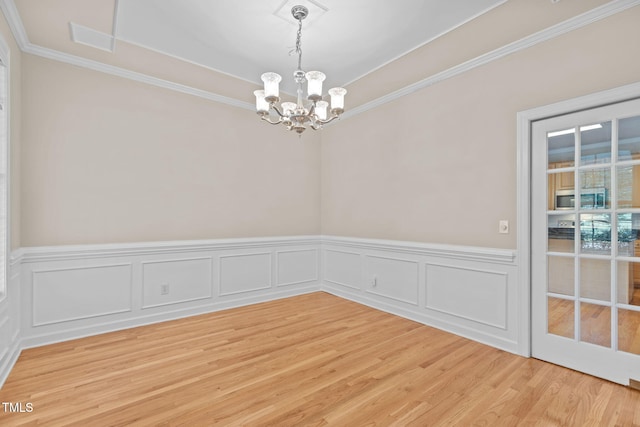 1806 White Dogwood Rd, Apex, NC 27502 - spare room featuring a chandelier, crown molding, light wood-style flooring, a wainscoted wall, and a tray ceiling