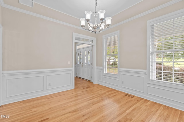 1806 White Dogwood Rd, Apex, NC 27502 - unfurnished room featuring a chandelier, a wainscoted wall, crown molding, plenty of natural light, and light wood-style flooring