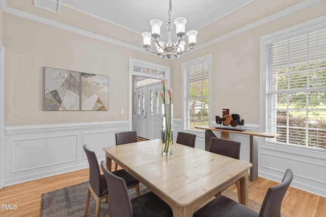 1806 White Dogwood Rd, Apex, NC 27502 - dining room with a chandelier, crown molding, a wainscoted wall, healthy amount of natural light, and light wood finished floors