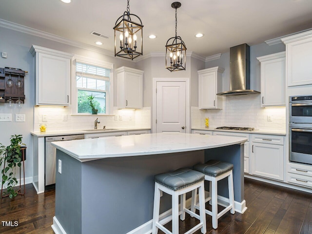 1004 Dogwood Bloom Ln, Knightdale, NC 27545 - kitchen with wall chimney exhaust hood, stainless steel appliances, a kitchen island, white cabinetry, and a chandelier