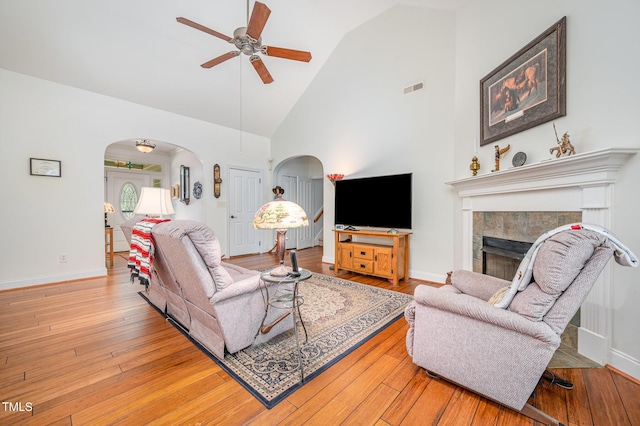 1513 Anterra Dr, Wake Forest, NC 27587 - living room with a ceiling fan, arched walkways, a tiled fireplace, high vaulted ceiling, and light wood-style floors