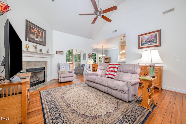 1513 Anterra Dr, Wake Forest, NC 27587 - living area featuring ceiling fan, a tiled fireplace, high vaulted ceiling, light wood-type flooring, and a chandelier