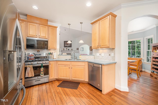 1513 Anterra Dr, Wake Forest, NC 27587 - kitchen featuring stainless steel appliances, arched walkways, light brown cabinetry, ornamental molding, and light wood-style flooring