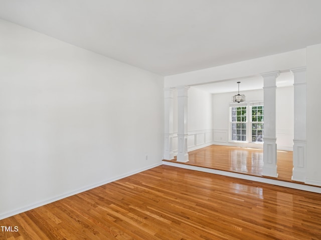 104 Pellinore Ct, Cary, NC 27513 - spare room with light wood finished floors, a wainscoted wall, a decorative wall, and a chandelier