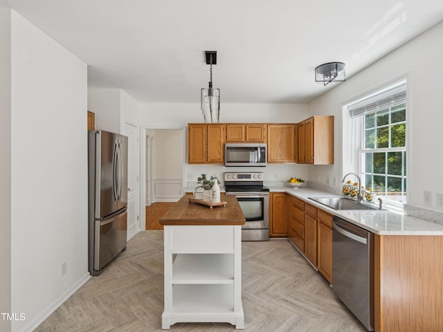 104 Pellinore Ct, Cary, NC 27513 - kitchen with appliances with stainless steel finishes, open shelves, a center island, brown cabinetry, and decorative light fixtures