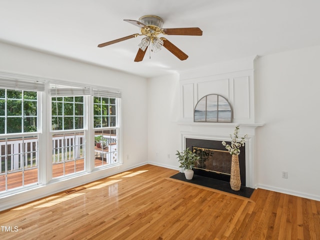 104 Pellinore Ct, Cary, NC 27513 - unfurnished living room featuring ceiling fan, a fireplace with flush hearth, and light wood-type flooring