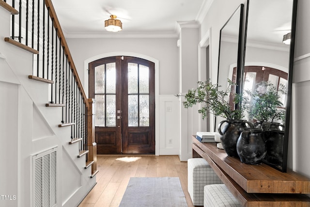 2105 Gardenbrook Dr, Raleigh, NC 27606 - entryway featuring arched walkways, stairway, ornamental molding, and hardwood / wood-style floors