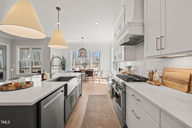 2105 Gardenbrook Dr, Raleigh, NC 27606 - kitchen featuring appliances with stainless steel finishes, custom exhaust hood, white cabinetry, tasteful backsplash, and a kitchen island with sink