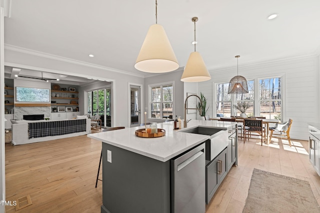 2105 Gardenbrook Dr, Raleigh, NC 27606 - kitchen with stainless steel dishwasher, light wood-style flooring, ornamental molding, a kitchen island with sink, and healthy amount of natural light