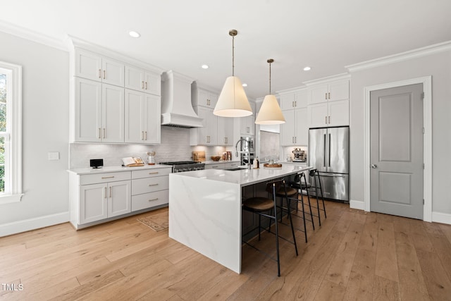 2105 Gardenbrook Dr, Raleigh, NC 27606 - kitchen with stainless steel appliances, custom range hood, a breakfast bar area, backsplash, and an island with sink
