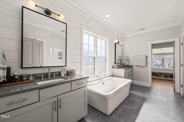 2105 Gardenbrook Dr, Raleigh, NC 27606 - bathroom with ornamental molding, vanity, a soaking tub, and tile patterned floors