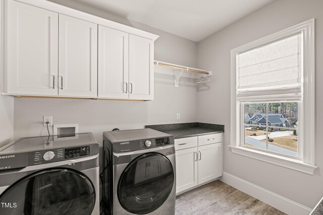2105 Gardenbrook Dr, Raleigh, NC 27606 - laundry area with independent washer and dryer, cabinet space, and light wood-style flooring