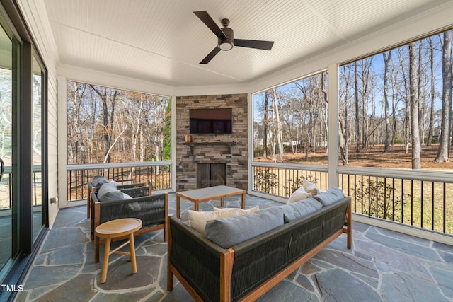 2105 Gardenbrook Dr, Raleigh, NC 27606 - sunroom with ceiling fan, an outdoor living space with a fireplace, and view of wooded area
