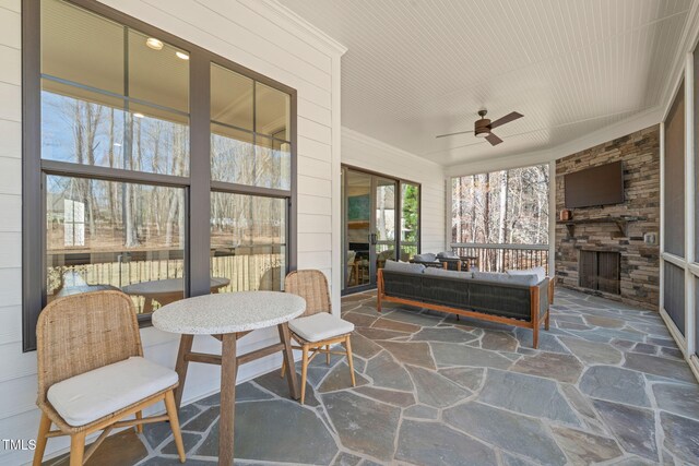 2105 Gardenbrook Dr, Raleigh, NC 27606 - sunroom / solarium with an outdoor stone fireplace, stone flooring, and a ceiling fan