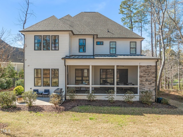 2105 Gardenbrook Dr, Raleigh, NC 27606 - back of property featuring a standing seam roof, a lawn, a patio area, and roof with shingles