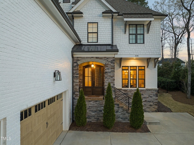 2105 Gardenbrook Dr, Raleigh, NC 27606 - view of front of home featuring a standing seam roof, brick siding, an attached garage, and a metal roof