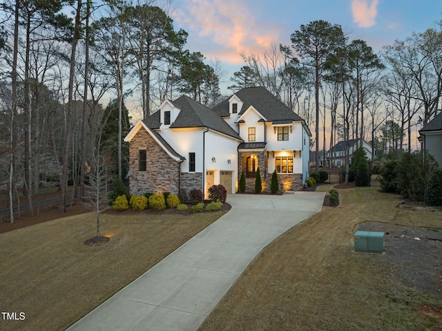 2105 Gardenbrook Dr, Raleigh, NC 27606 - view of front facade with concrete driveway, stone siding, stucco siding, a front yard, and a garage