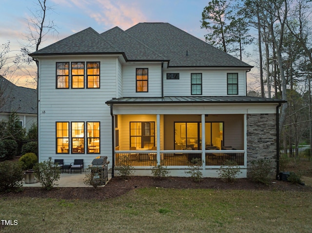 2105 Gardenbrook Dr, Raleigh, NC 27606 - back of property with a standing seam roof, a yard, a porch, a shingled roof, and a metal roof