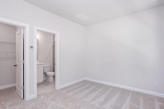 4703 Mint Leaf Ln, Raleigh, NC 27612 - unfurnished bedroom with a walk in closet, carpet flooring, and a closet